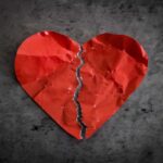 Cuore rosso di carta, stropicciato e strappato in due