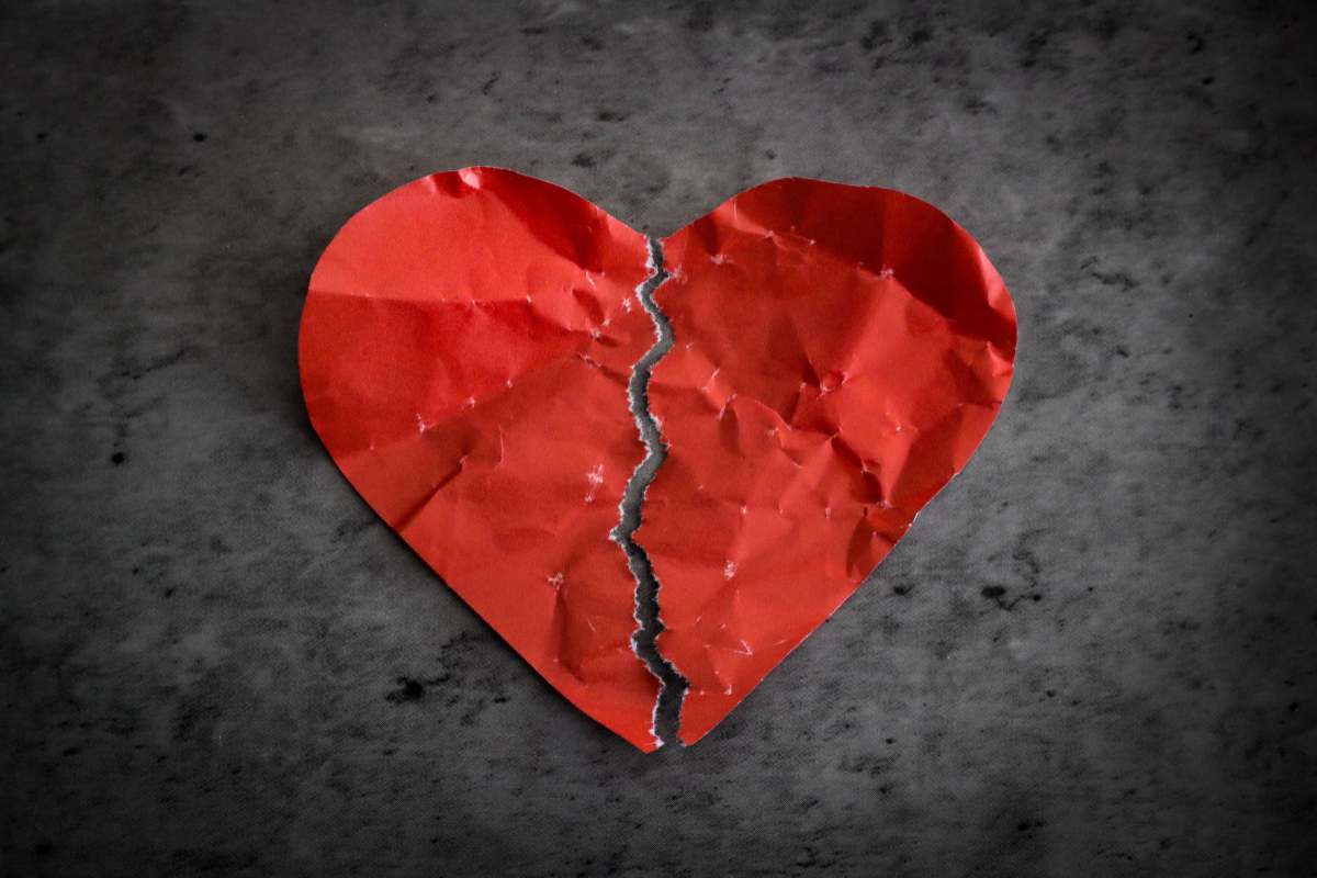 Cuore rosso di carta, stropicciato e strappato in due