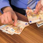 uomo che conta banconote da 50 euro
