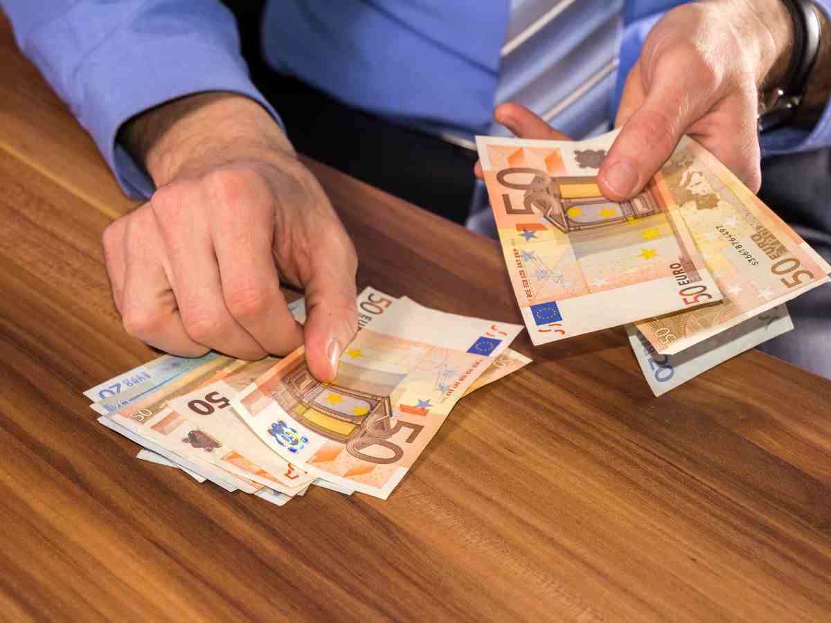 uomo che conta banconote da 50 euro
