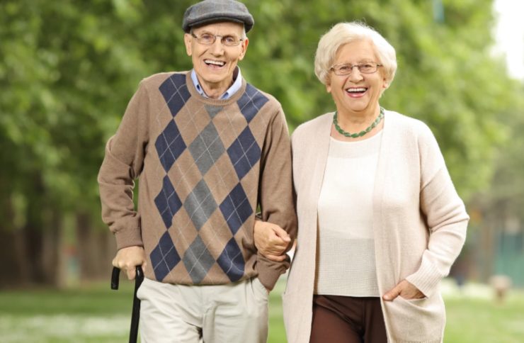 coppia di anziani sorridenti che camminano a braccetto