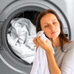 sfondo asciugatrice in azione e donna che odora panni puliti