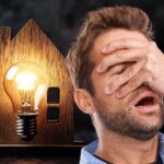 sfondo casa in miniatura con lampadina e uomo sconvolto