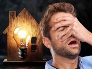 sfondo casa in miniatura con lampadina e uomo sconvolto