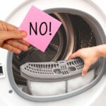 sfondo asciugatrice e mano con cartellino che dice no
