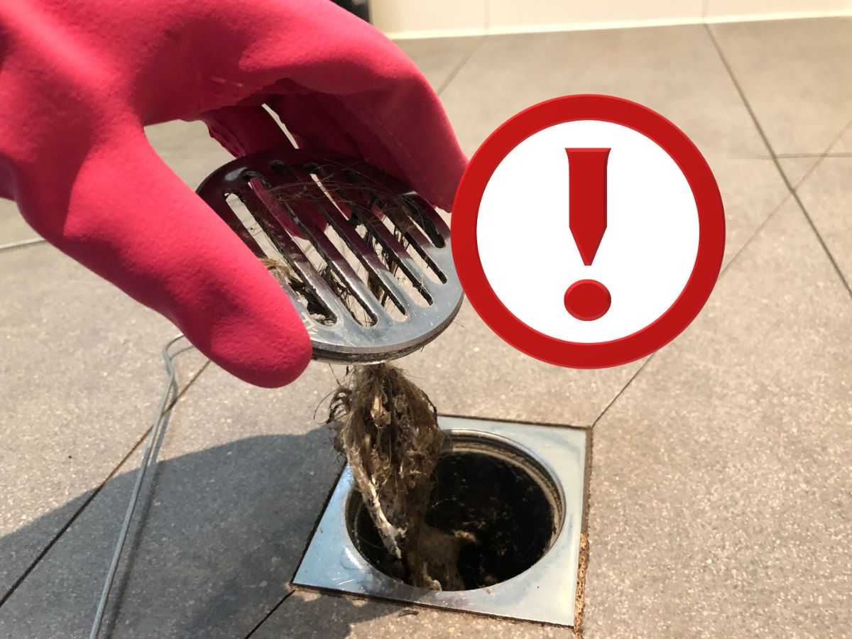 capelli nello scarico della doccia, guanto rosso e punto esclamativo 