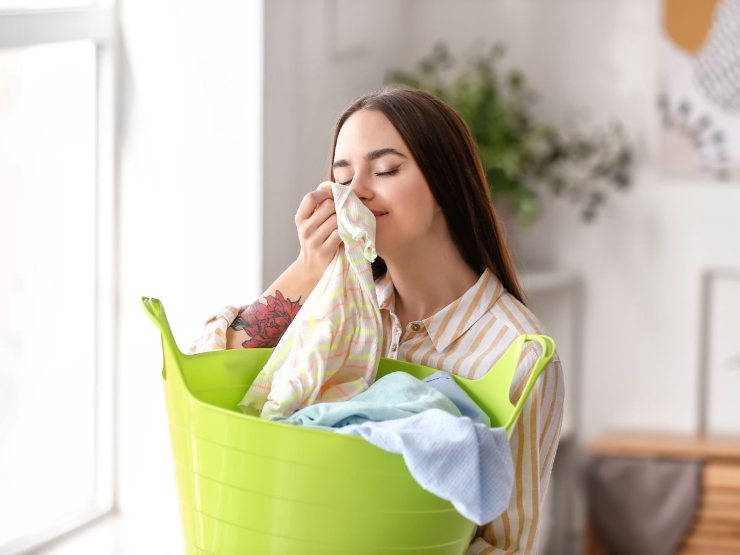 ragazza odora vestiti puliti da cesta