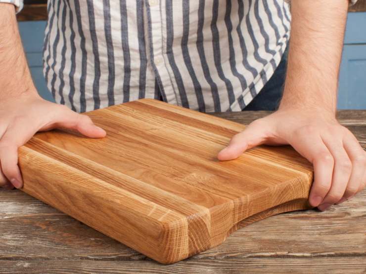 uomo con tagliere di legno