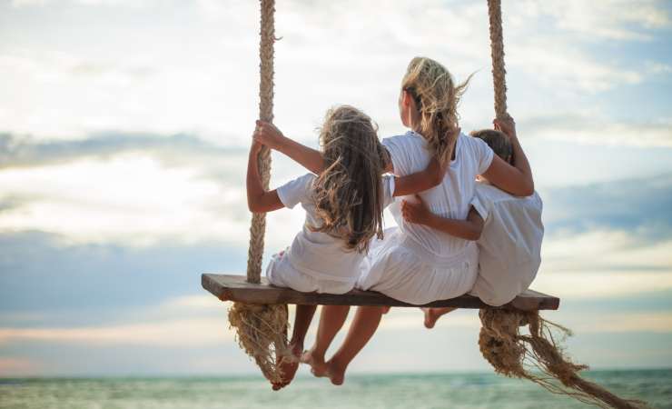madre sull'altalena con i figli