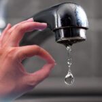 sfondo rubinetto che gocciola e mano che fa ok